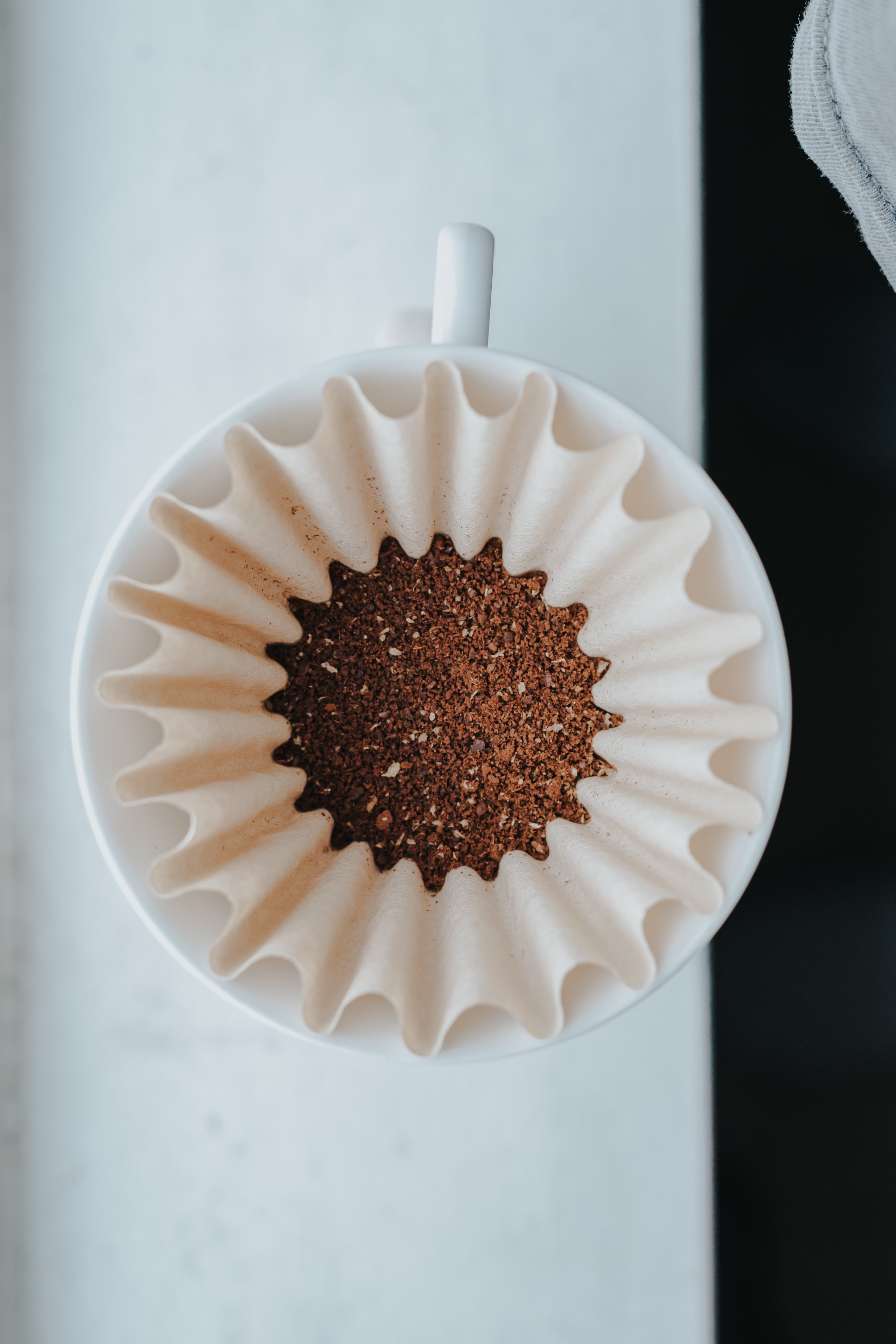 Ground coffee in a paper filter seen from above.